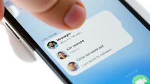 Close-up of iPhone screen showing Messages app with group conversation thread visible, finger hovering over swipe-left gesture, clean white background, daytime lighting
